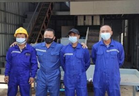青い作業着を着た男性4人